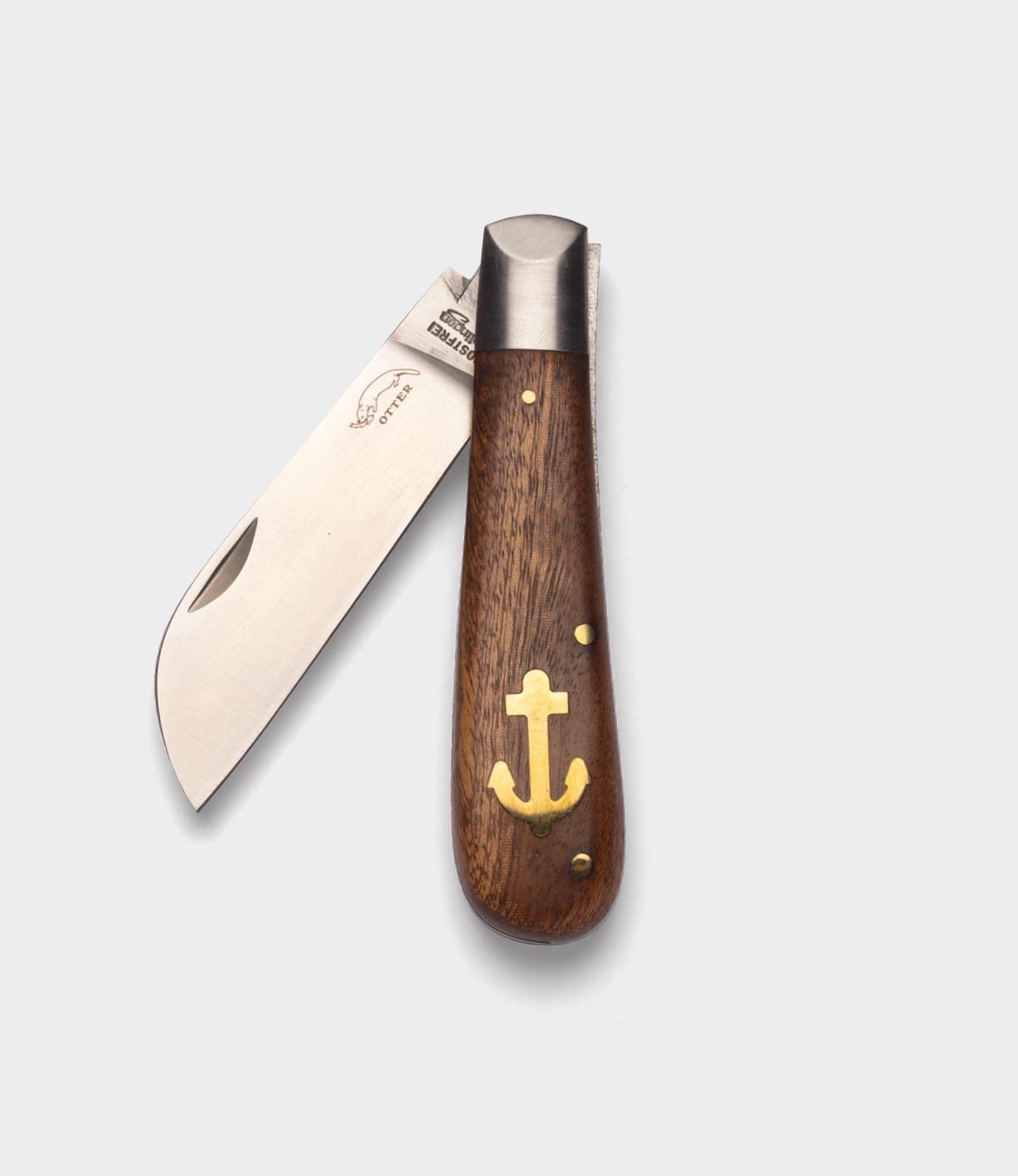 The Best Made Co. Anchor Knife is a folding nautical knife with a partially open sheepsfoot blade and a wooden handle featuring a brass anchor inlay, shown on a plain light gray background.