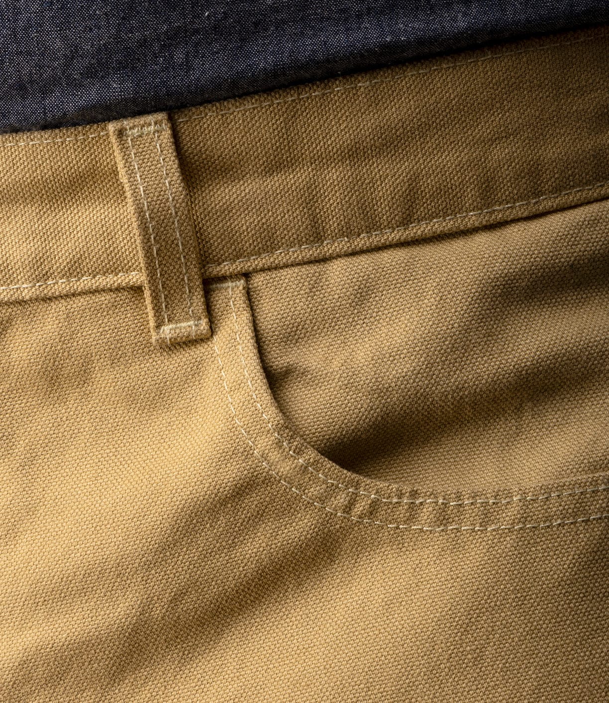 Close-up of Best Made Co Standard 5-Pocket Pant M2 Khaki, showing heavyweight cotton fabric, waistband, belt loop, and detailed stitching on the front pocket with a dark shirt partially visible at the top.