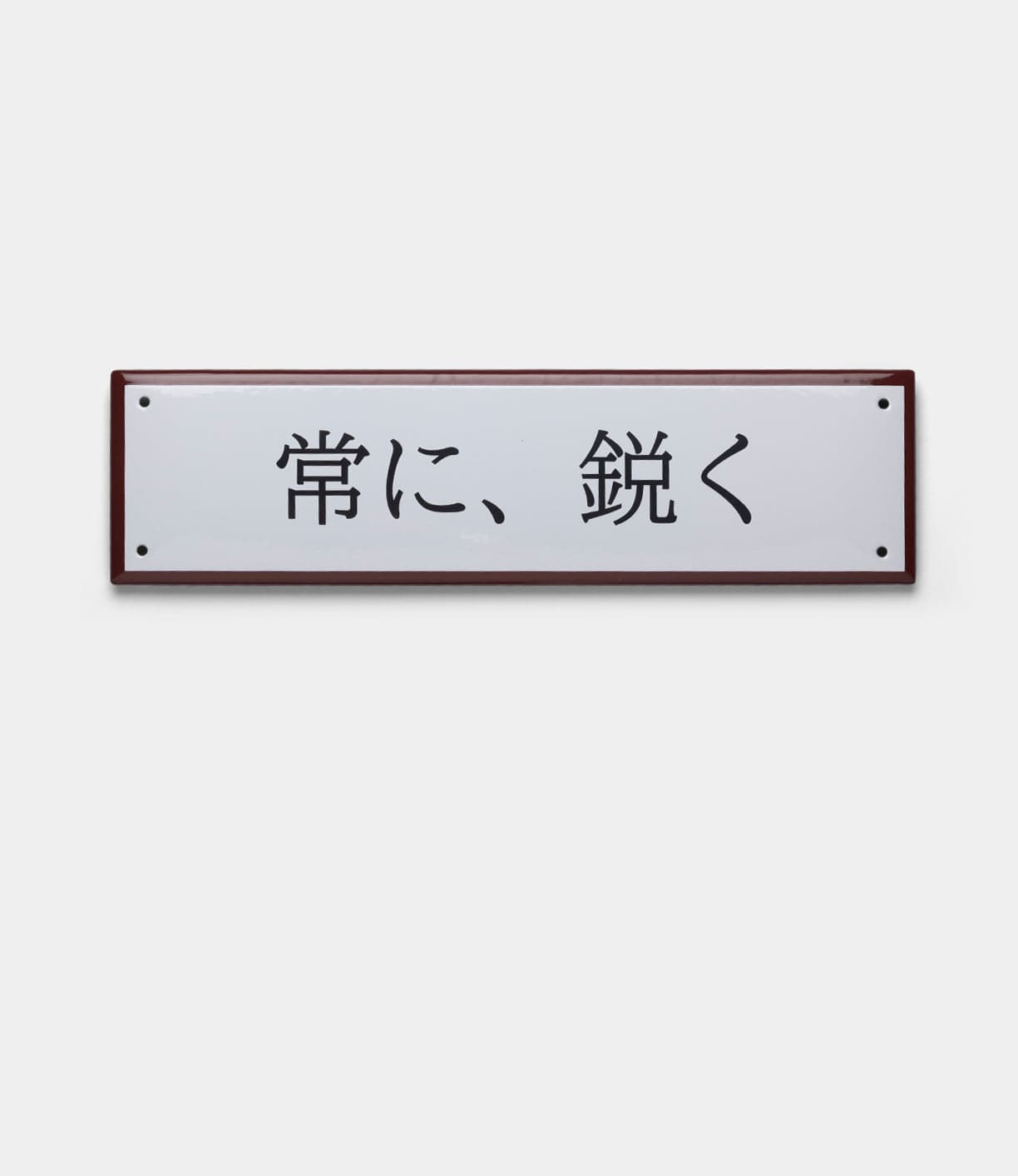 The Best Made Co. “Stay Sharp” Enamel Steel Sign (Kanji Edition) features a handcrafted rectangular white enamel design with black 常に、鋭く text, red-brown border, and is inspired by the precision of Japanese blades.