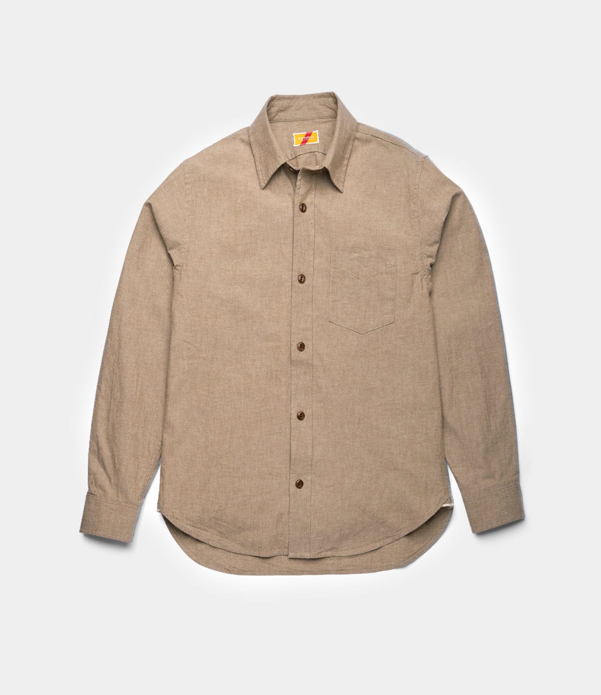 The Best Made Co. Cotton/Linen Herringbone Workshirt in tan is a long-sleeve workwear shirt with a single chest pocket, brown buttons, and a pointed collar, shown laid flat on a white background.