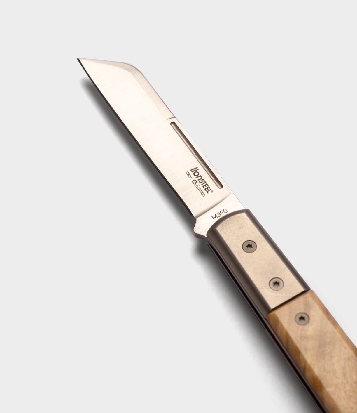 The Best Made Co. Italian Barlow is a folding knife with a straight-edged blade and wooden handle, shown partially open on a light gray background. The blade is engraved "HD STEEL M390," highlighting its premium M390 stainless steel construction.