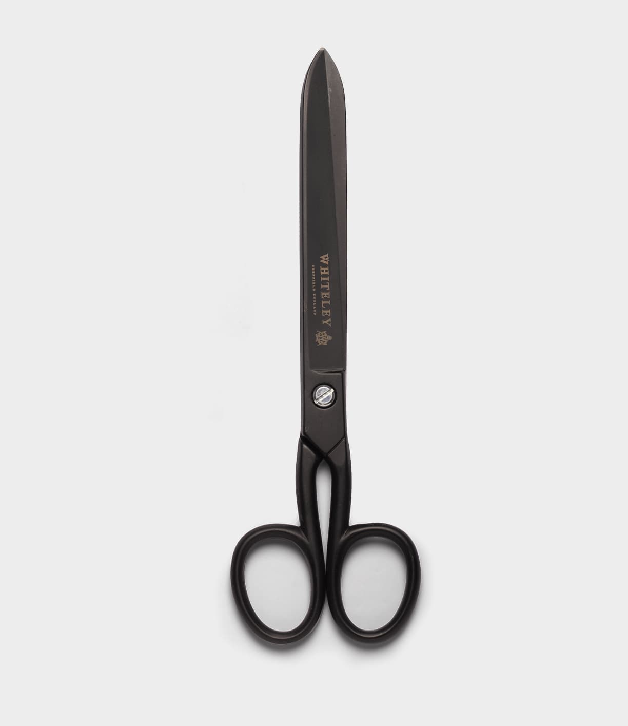 A pair of Best Made Co. Ten-Inch Paper Scissors, featuring large black ergonomic handles and sharp hot-forged carbon steel blades, stand vertically on a plain white background.
