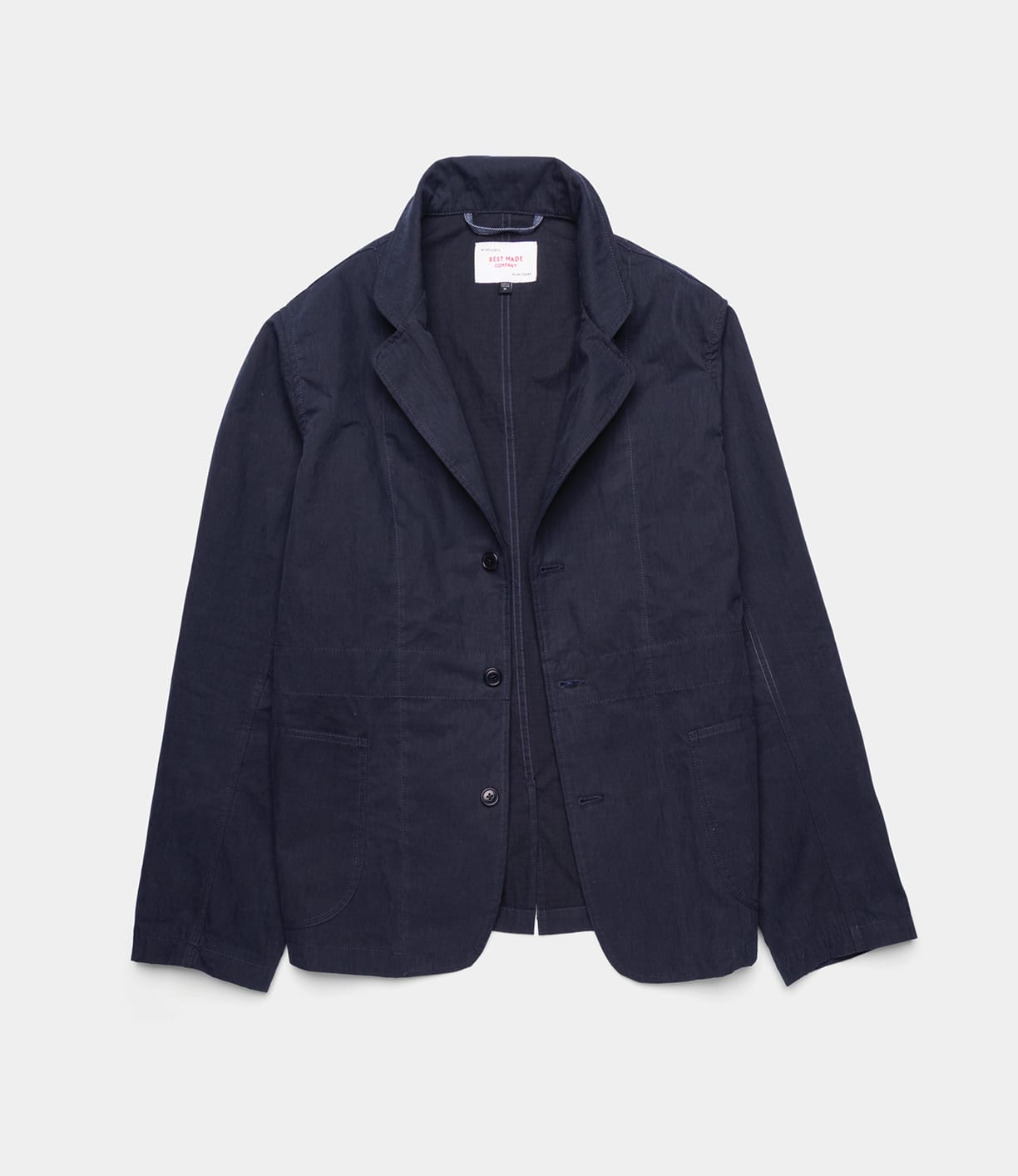 The Best Made Co Possibilities Jacket Navy features a notched lapel, three front buttons, and two side pockets—an example of American craftsmanship—displayed flat against a white background.
