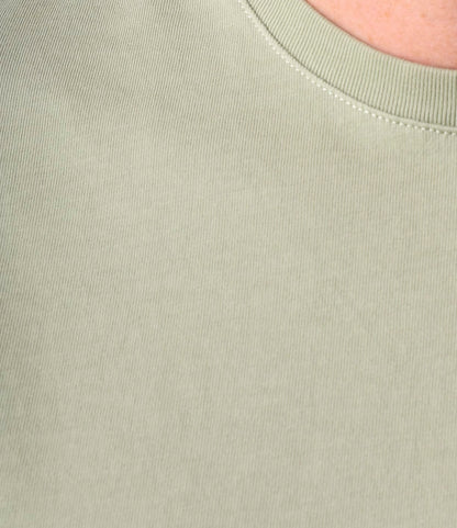 Close-up of the Best Made Co. Standard Pocket T-Shirt Haze in light sage green ribbed fabric, crafted from durable Peruvian tangüis cotton. Features collar seams and textured material—an everyday essential.