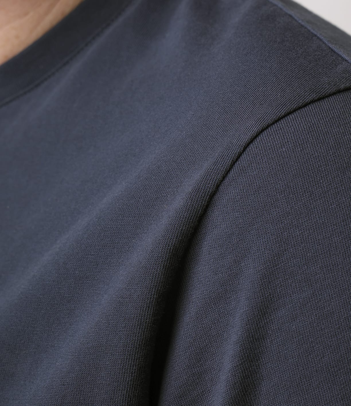 Close-up of a person wearing the Best Made Co Standard Pocket T-Shirt in Navy, focusing on the shoulder and upper chest to show off the premium cotton fabric texture and detailed stitching.