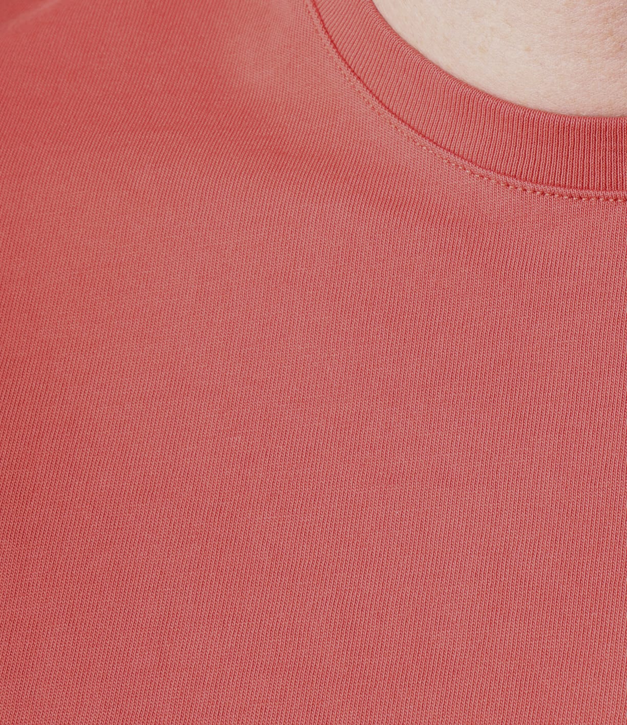 Close-up of a person wearing the Best Made Co Standard T-Shirt in Faded Red, showing only the neckline, shoulder, and part of the neck; background not visible. Crafted with Peruvian tangüis cotton and finished with a garment-dye technique.