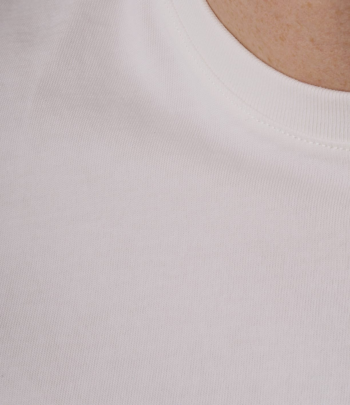 Close-up of the Best Made Co Standard T-Shirt Undyed, showcasing its durable Peruvian tangüis cotton with detailed fabric texture and stitching near the collar, worn to show part of the neck and chest area.