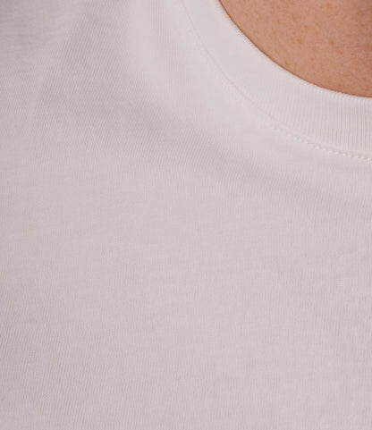 Close-up of a person wearing the Best Made Co. Standard T-Shirt Undyed. The image highlights its soft texture and classic neckline, with part of the wearer’s neck and shoulder shown in the top right corner.