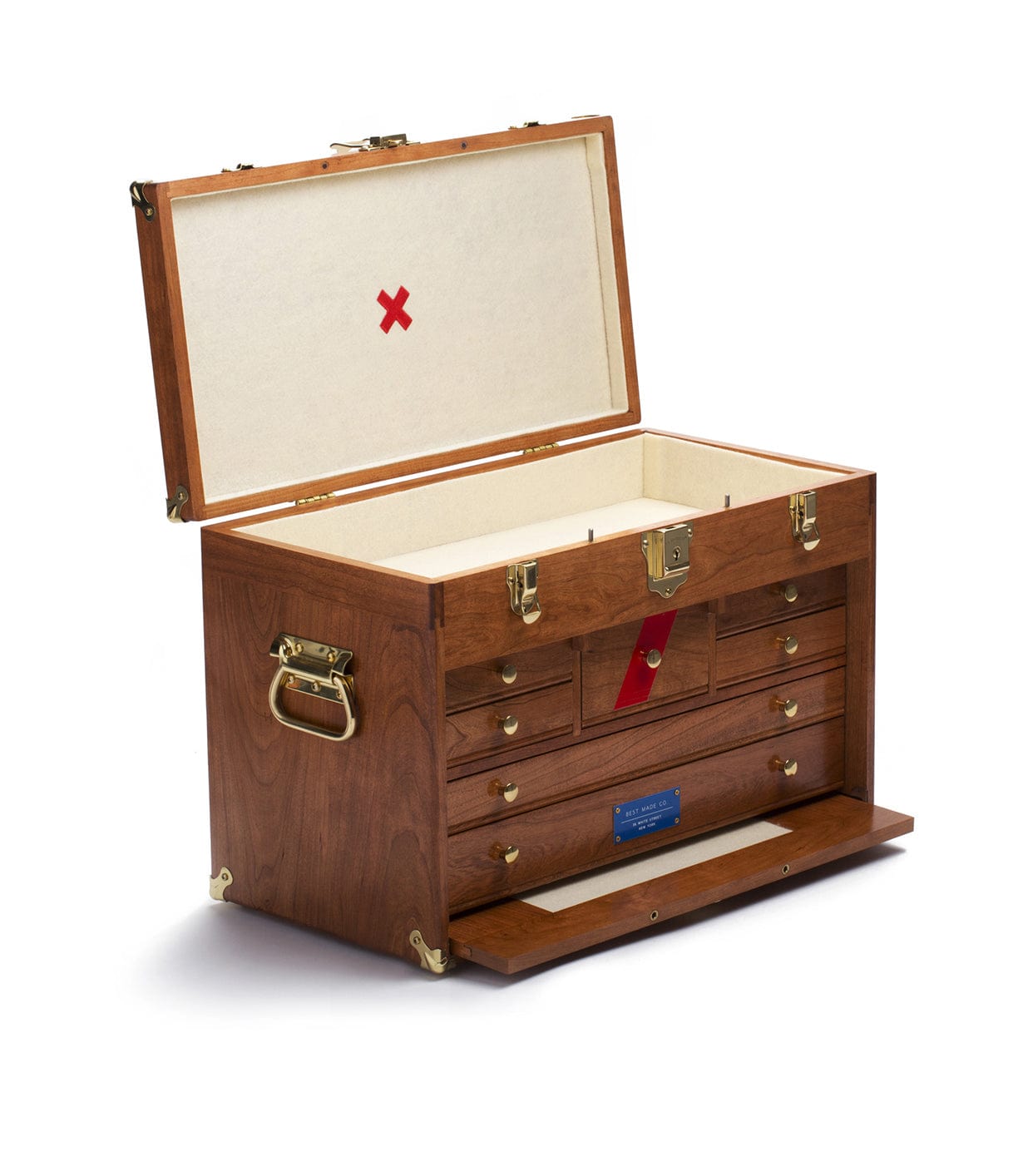 The Best Made Co. 41D Gerstner Chest 2026 features American cherry wood, brass hardware, side handles, a pull-down lower drawer panel, interior small drawers, a lift-out tray, and a cream lid marked with a red X.