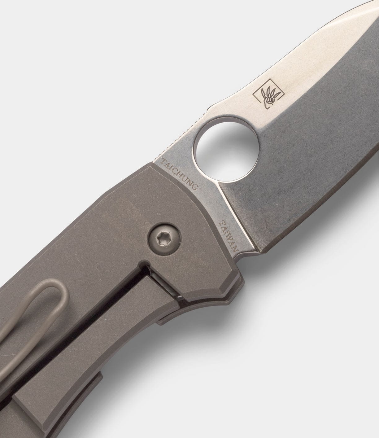 Close-up of a Best Made Co Spyderco Techno 2 pocket knife with CTS-XHP steel blade, thumb hole, logo, and TAICHUNG TAIWAN engraving. Features a matte titanium framelock handle and pocket clip.