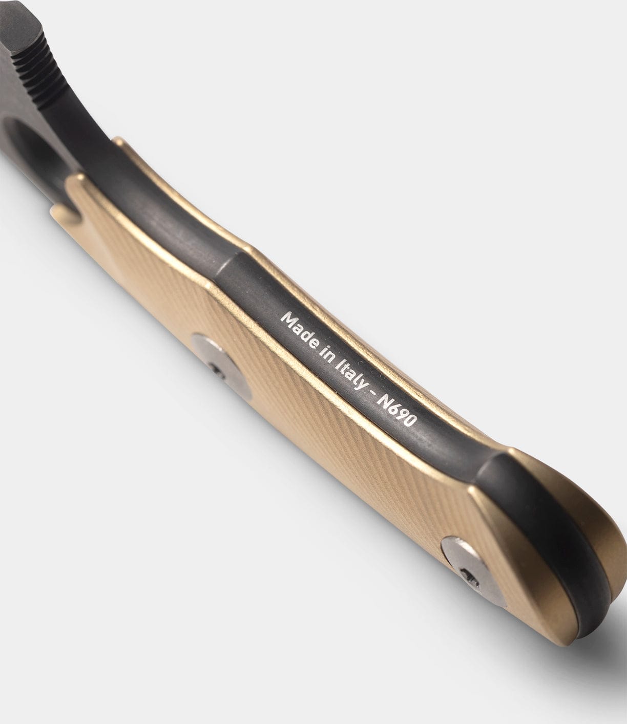 A close-up of the Best Made Co GiantMouse GMF1-P (BMC Edition) knife handle with a gold finish, featuring "Made in Italy - N690" on the metal spine against a light gray background.