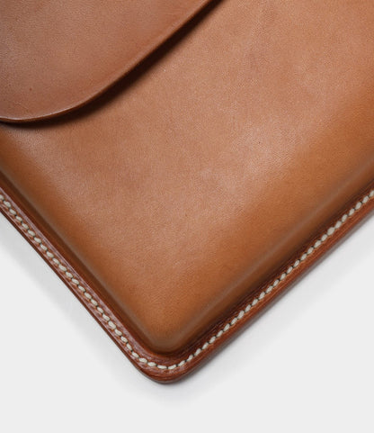 Close-up of a Best Made Co. Gfeller Case Small, featuring tan hand-stitched leather with visible edge stitching and a flap partially covering the top left corner.