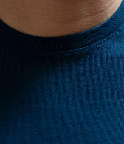 Close-up of a person's neck and upper chest in the Best Made Co. Standard T-Shirt Signal Blue, highlighting the fabric texture and collar detail that showcase the quality and durability of Peruvian tangüis cotton.