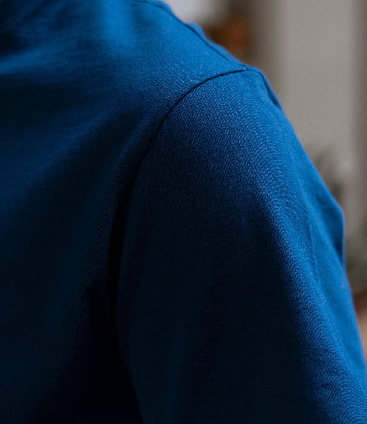 Close-up of a person wearing the Best Made Co Pocket T-Shirt in Haze Gray, crafted from soft Peruvian tangüis cotton, highlighting the shoulder and upper chest with an out-of-focus background.