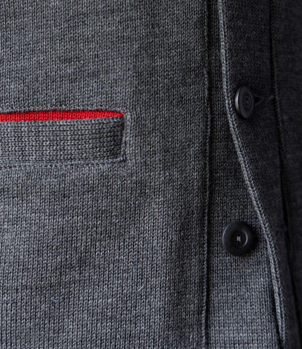 Close-up of the Dehen Shawl Neck Sweater in Charcoal by Best Made Co.—a gray worsted wool knit jacket with black buttons and a small pocket edged in red, blending classic American workwear style.