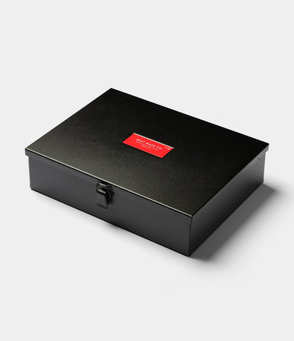A closed, rectangular matte black steel Type 12 Strongbox by Best Made Co., featuring a front clasp and a red SILHOUETTE COLLECTION label on the lid, designed for secure storage and shown against a plain white background.