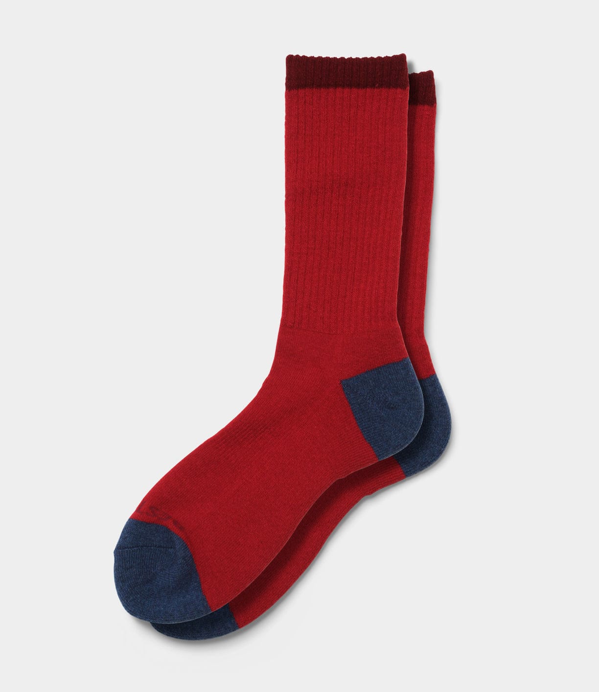 The Standard Wool Sock by Best Made Co is a red crew sock with dark blue heels and toes, plus a dark red cuff. Made in the USA, it's ideal for daily wear and shown on a light background.