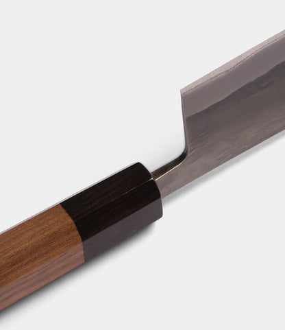 Close-up of the Best Made Co. Aogami Nakiri Knife, featuring a wooden handle and a shiny, rectangular Blue Paper Steel No. 2 blade, set against a plain white background.