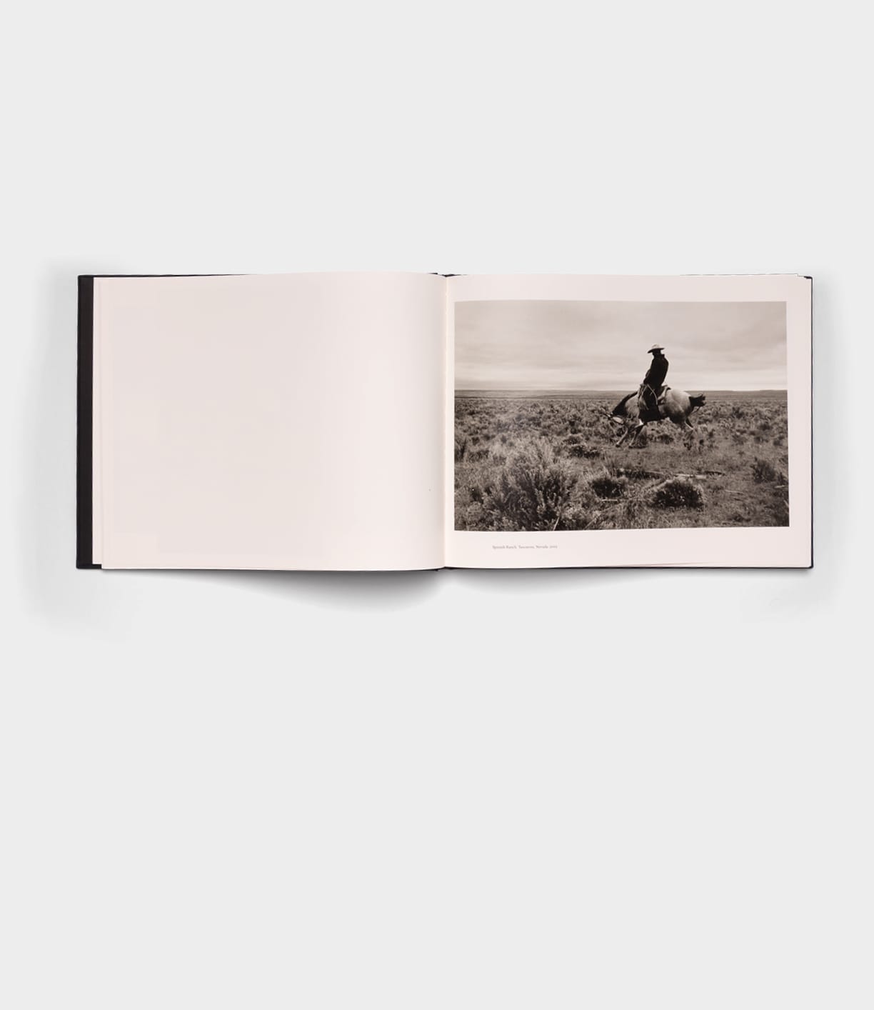 Open Range by Best Made Co. is an open photography book featuring a black-and-white photo of a person riding a horse across grassy land, with the opposite page left blank.