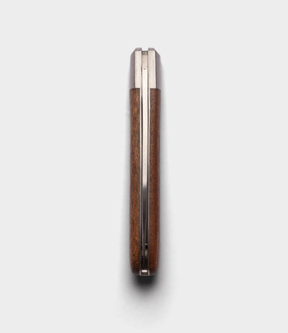 A closed Best Made Co. Otter-Messer Pocket Knife with a sapele handle is shown top-down on a white background, revealing only the carbon steel blade's edges and metal spine.