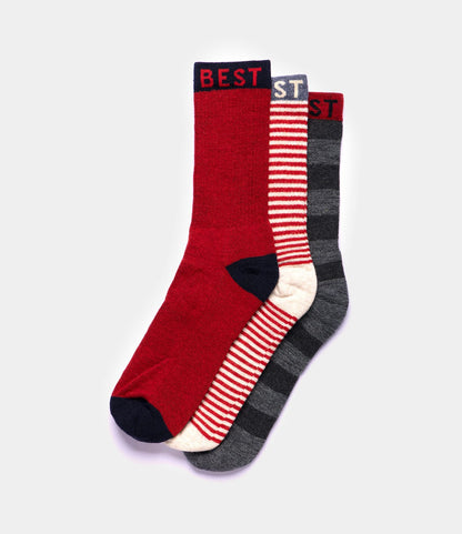 Three pairs of Best Made Co. Standard Wool Socks: one solid red with navy accents labeled BEST, one red and white striped, and one dark gray with black stripes—all designed for all-season comfort.
