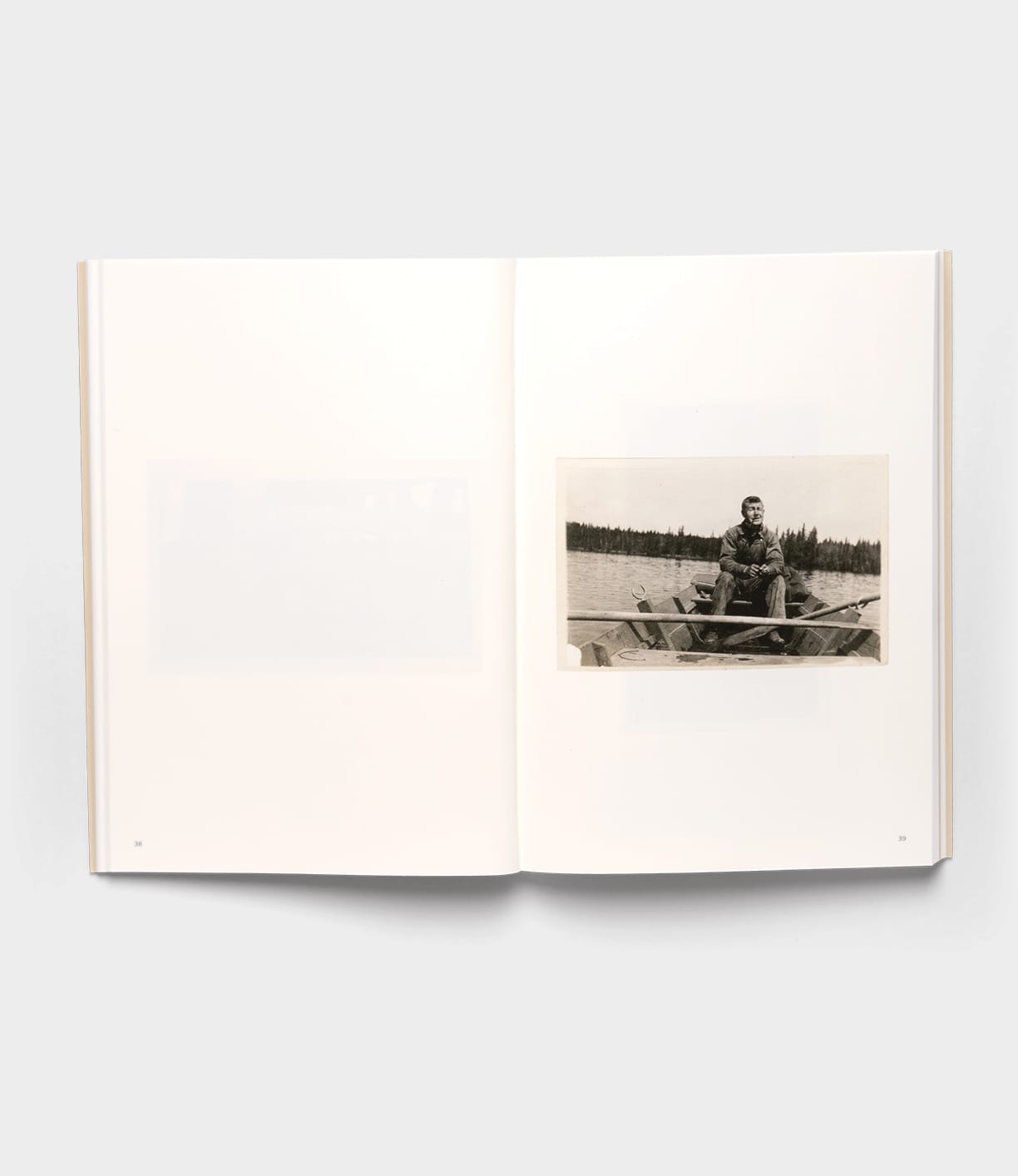 The open book "Will Write Soon" by Best Made Co. shows a black-and-white postcard-style photo of a person in a small boat on a tree-lined lake; the left page is mostly blank against a plain white background.