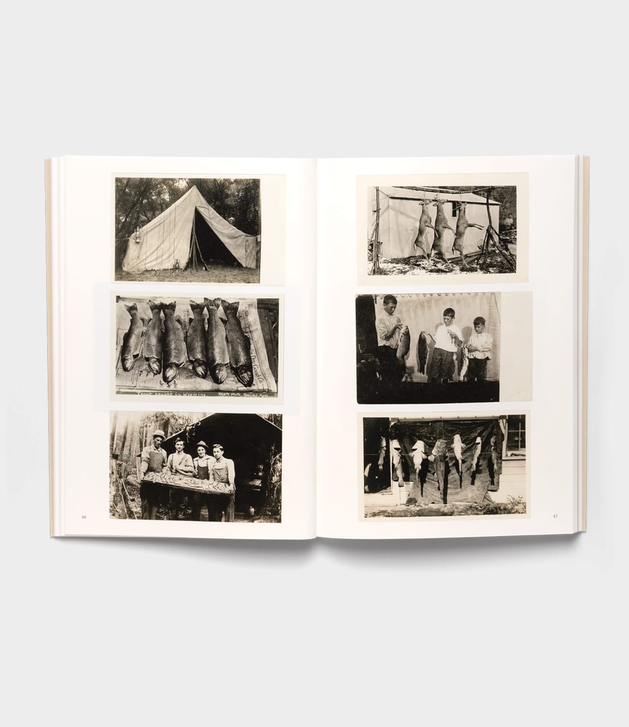 The open book "Will Write Soon" by Best Made Co. showcases six black-and-white vintage photos of rural America, featuring a tent, animal pelts, anglers with caught fish, and a group outside a rustic cabin.