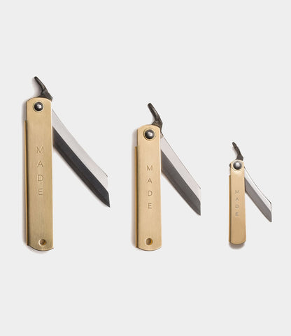 Three Best Made Co. Mid Brass Higo Knives, inspired by the classic Japanese folding knife, are displayed side by side with partially open blades and "MADE" engraved on each handle against a plain white background.