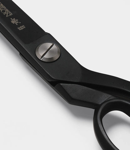 Close-up view of Best Made Co. Kevlar Shears—black industrial scissors with a metal pivot screw, showing part of the handle and upper blade against a white background.