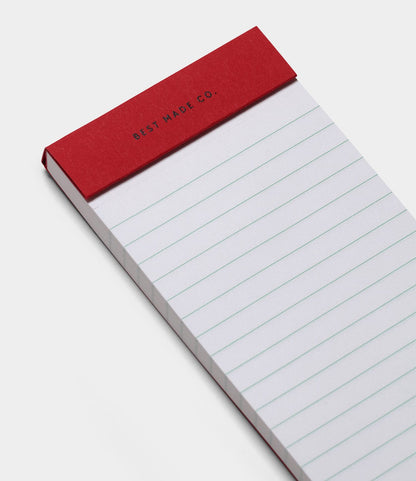 The S.B.T. List Pad by Best Made Co. is a portable notepad with a red cover and lined white pages, labeled with the brand name at the top, shown angled against a white background.