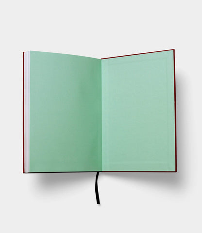 The S.B.T. Mid Cloth-Bound Notebook by Best Made Co. features red covers, light green blank pages, and a black ribbon bookmark, shown open on a white background.